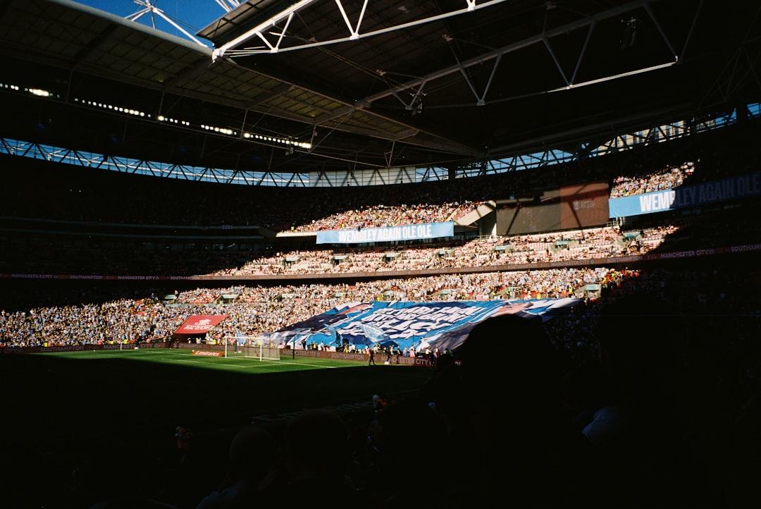 Fans packed into a stadium with a large banner on the pitch