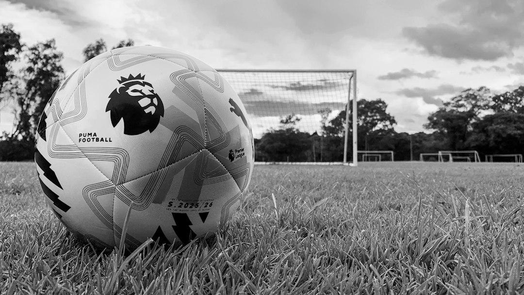 A soccer ball on a grassy field with goalposts