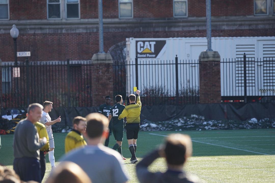 Referee officiating on a soccer field during the day