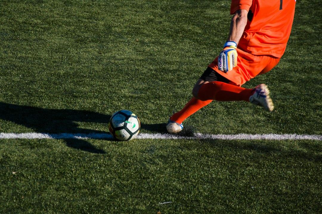 A football player striking the ball on the pitch