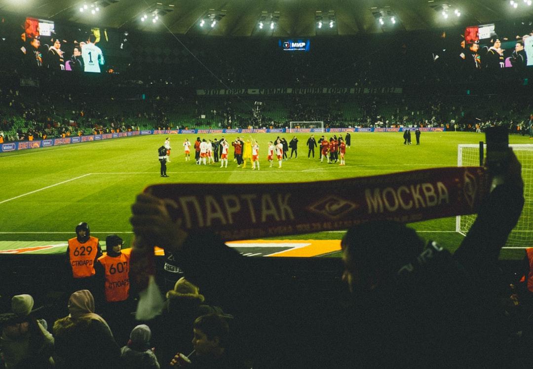 A fan holding a club scarf at a night football match