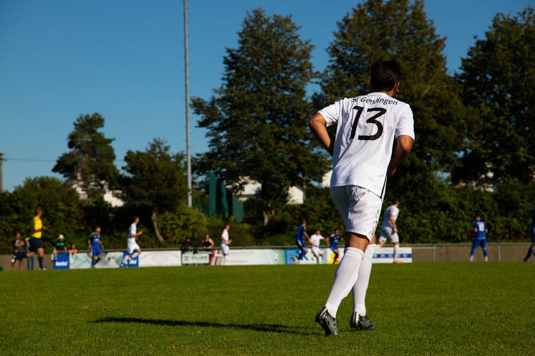 Football players on a pitch during an evening match