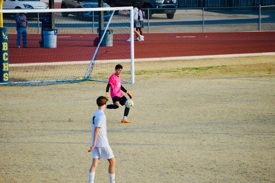 Goalkeeper in pink jersey on a soccer field