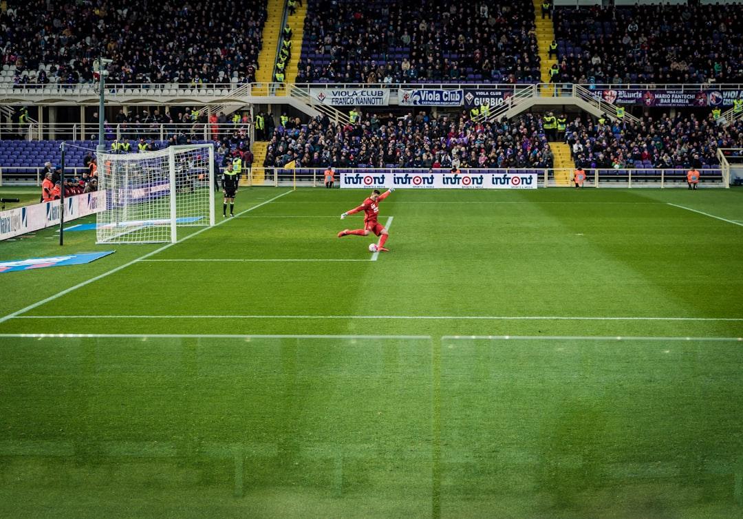 Players contesting a free kick near goal during a soccer match