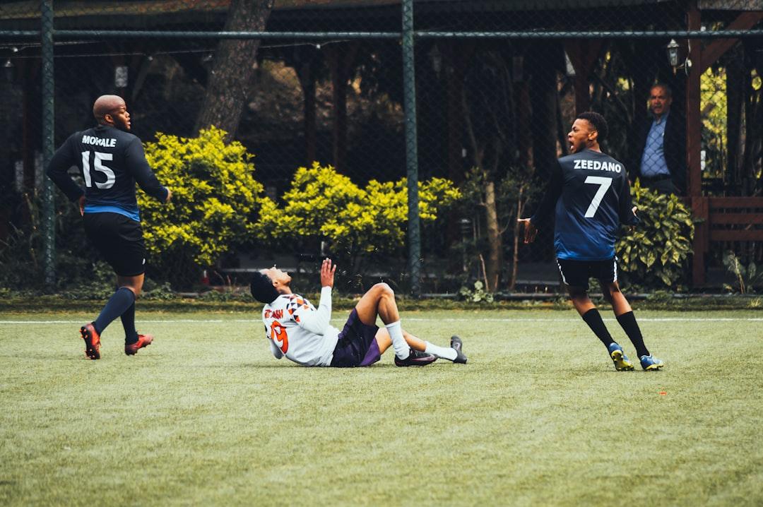 Players contesting a free kick on a green pitch