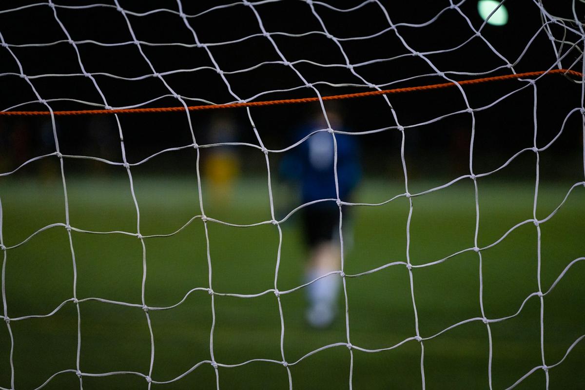 A footballer taking a free kick toward the goal