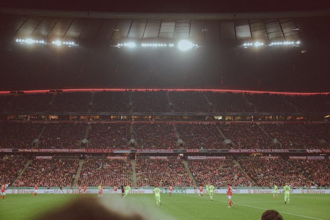 A soccer player standing on a floodlit pitch