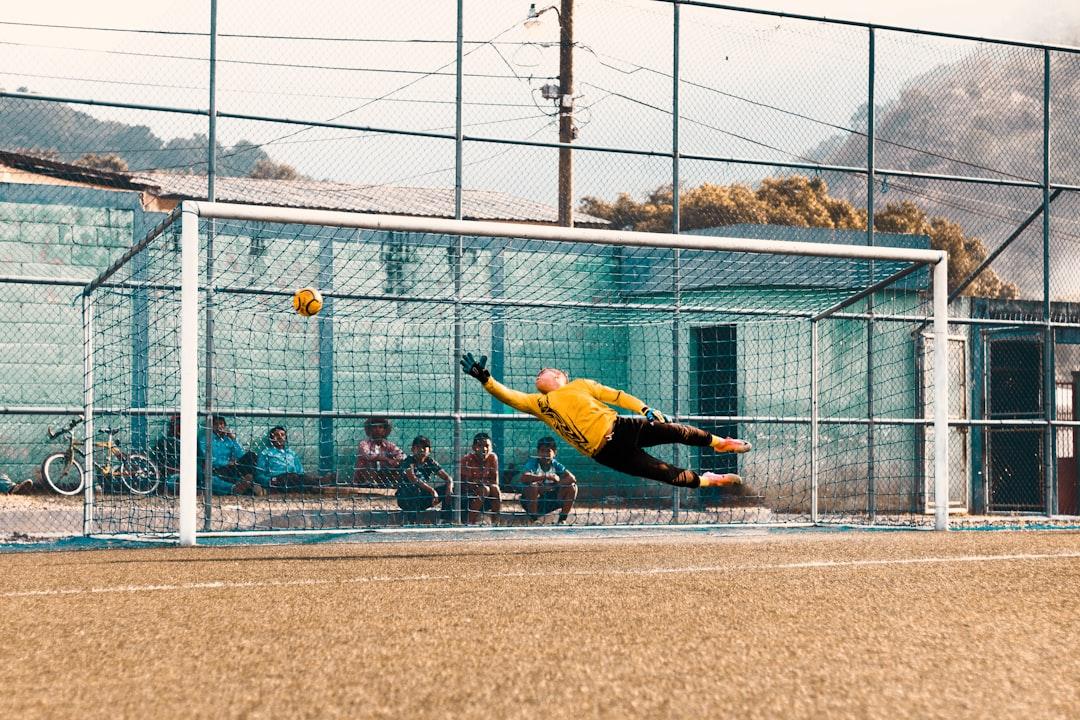 A goalkeeper jumping for the ball in front of goal