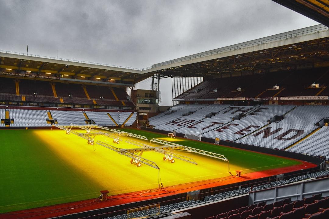 An empty football stadium with bright lights on the pitch