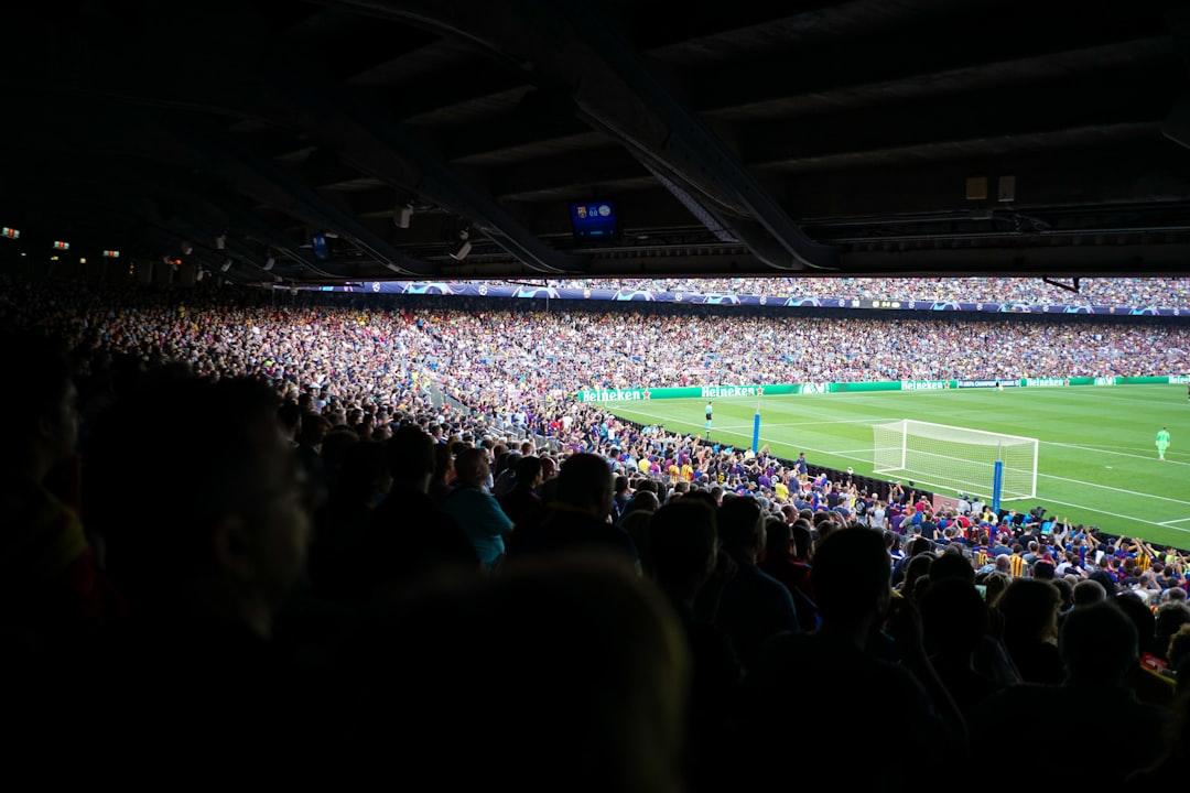 People watching football at a stadium during daytime