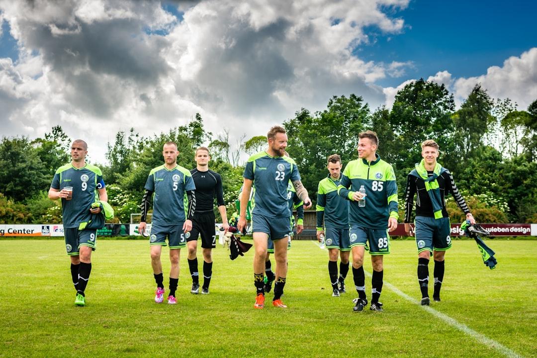 Football fans on a pitch gathered together in matching jerseys