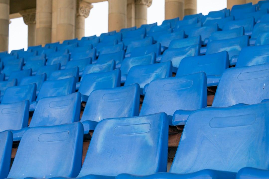 Rows of blue stadium seats before a match