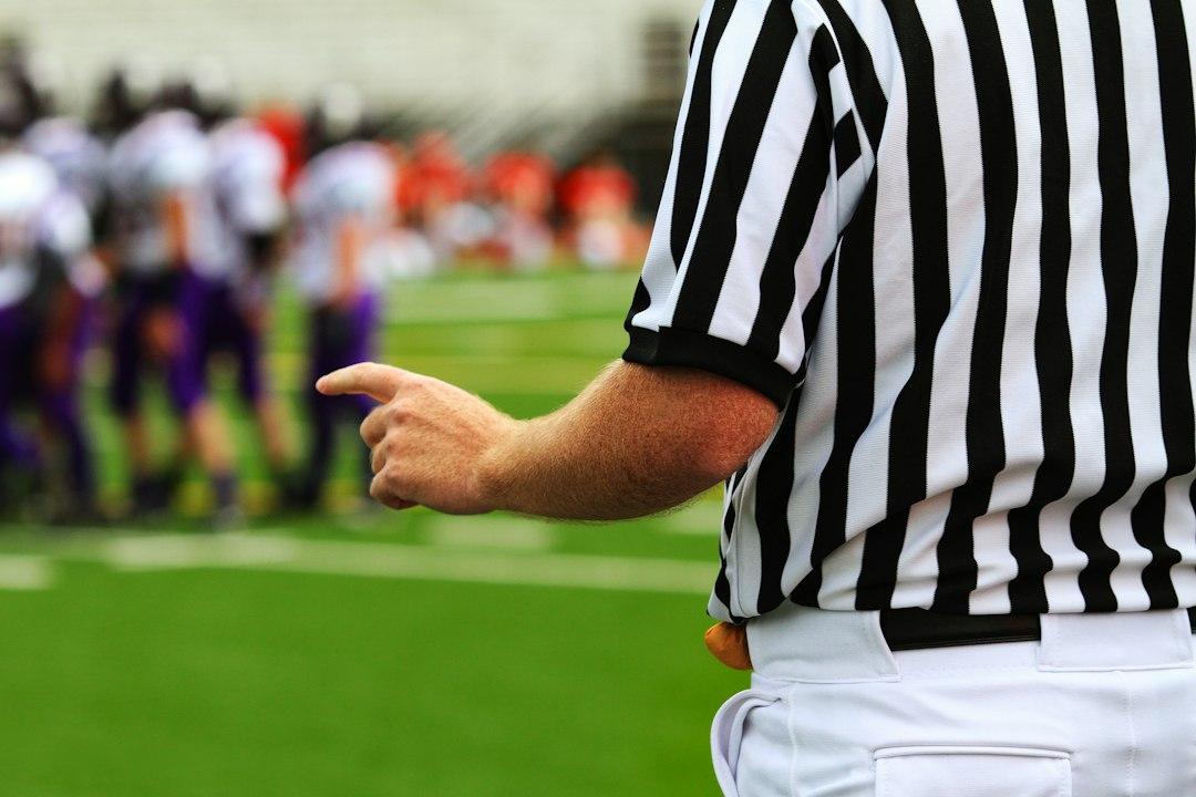 A referee standing on a football pitch during a match
