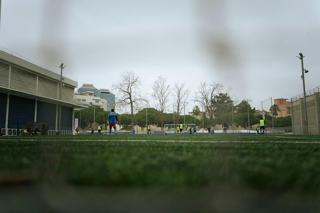 Players gather during a soccer match under cloudy skies