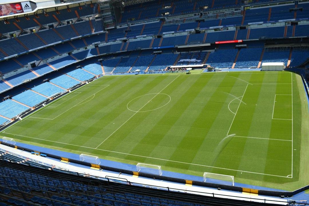 A sports stadium with a green field under open sky